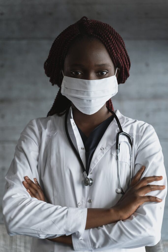 pexels-photo-5452201 Portrait of a confident female doctor wearing a mask and stethoscope, arms crossed.